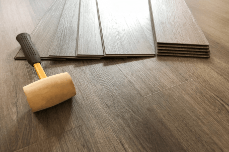 floor hammer and dark brown vinyl wood planks