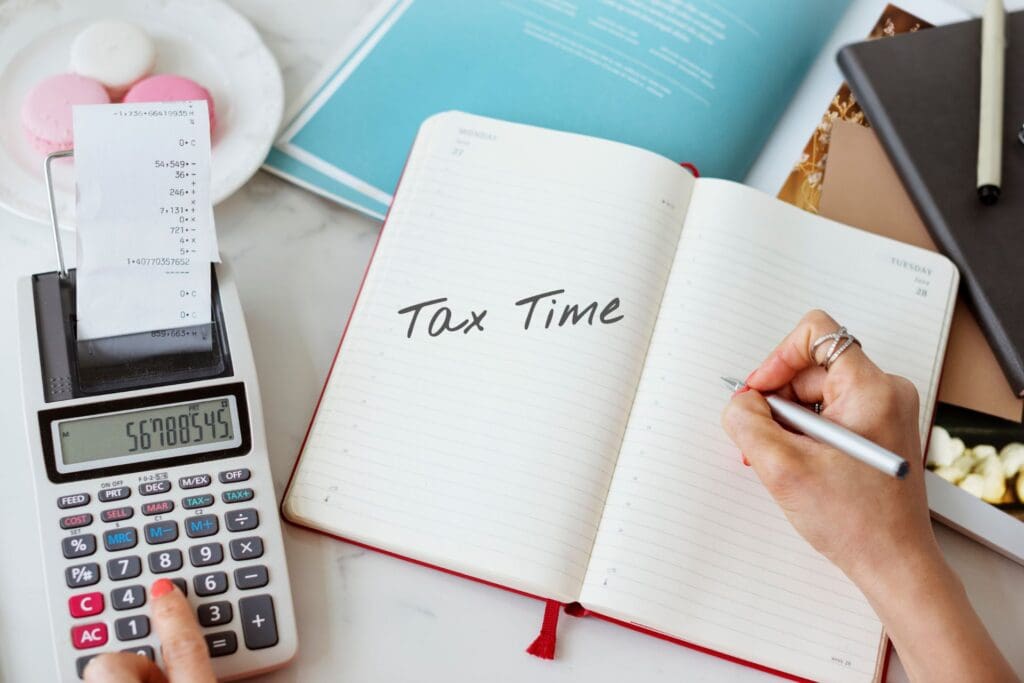 A notebook labeled "Tax Time" and a calculator highlight the stress of tax season and the importance of understanding tax deductions.