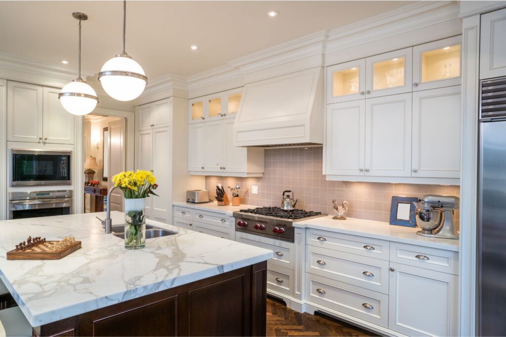 Upscale kitchen with white cabinets, marble counters, and hardwood floors, proof that Texas rental property compliance can still look this good.