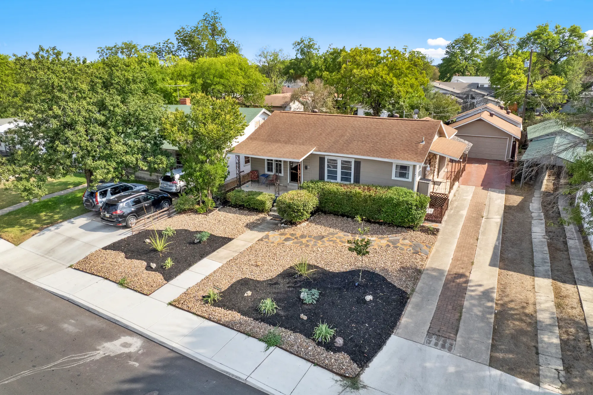 Single-story rental home with a xeriscaped front yard in a tree-lined Austin, Texas neighborhood.